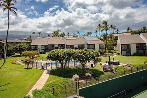 A residential building complex with multiple apartment units, a swimming pool, and lush landscaping. - Hale Kamaole 328 Third floor condo, easy access to best beach on Maui! (Kihei)