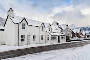 A row of white buildings with snow-covered roofs and a road in front. - Lochleven B&B Killin (Killin)