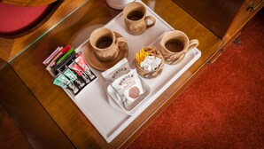 Una bandeja con dos tazas de cerámica, un paquete de galletas con chispas de chocolate y un paquete de bolsitas de té sobre una mesa de madera.