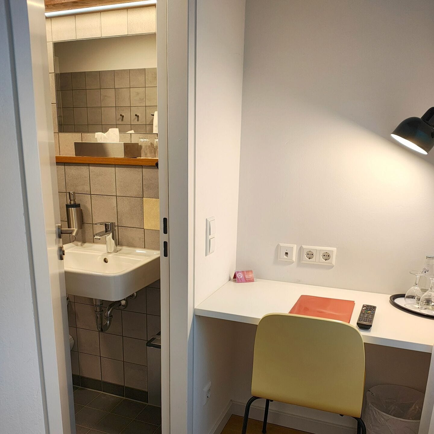 Una kitchenette compacta con un lavamanos, una encimera y una silla.