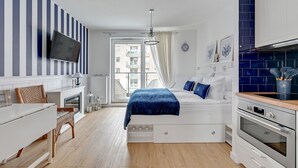 Un dormitorio moderno con una cama, una mesita de noche y un televisor fijado en la pared.