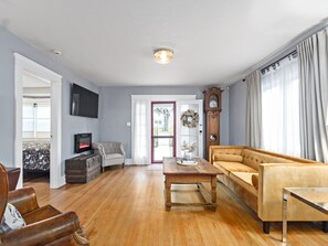 TV connectée, cheminée, livres, chaîne hi-fi