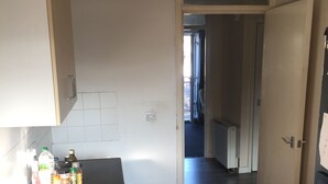 Una cocina con estufa, armarios y encimera con diversos objetos.