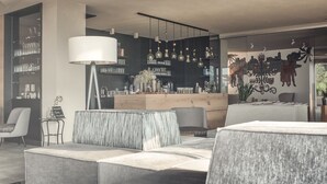 A modern interior with a bar area, seating, and decorative elements. - Das Wanda (Caldaro Sulla Strada del Vino)