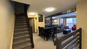 Portaat johtavat oleskelutilaan, jossa on ruokapöytä, tuoleja, sohva ja taustalla keittiö.