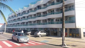 Ein mehrstöckiges Hotel mit Balkonen, einem Parkplatz und Blick auf die Straße.