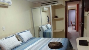 Ein Hotelzimmer mit einem Bett, einem Nachttisch, einem Kleiderschrank und einem kleinen Schreibtisch.