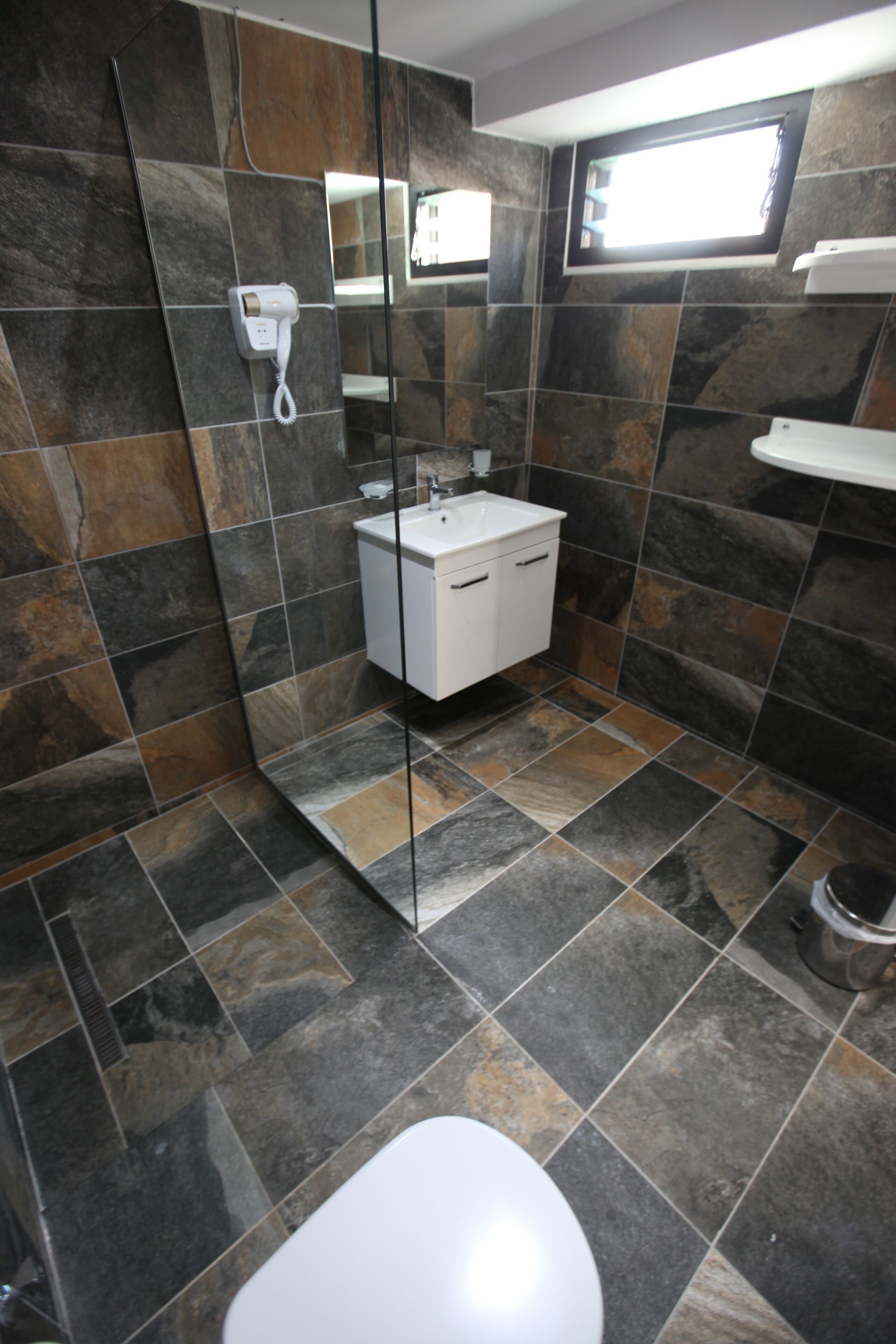 Un bagno con un water bianco, un lavandino e uno spazio doccia.