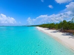 Ein Strand mit klarem türkisblauem Wasser und einem sandigen Ufer.