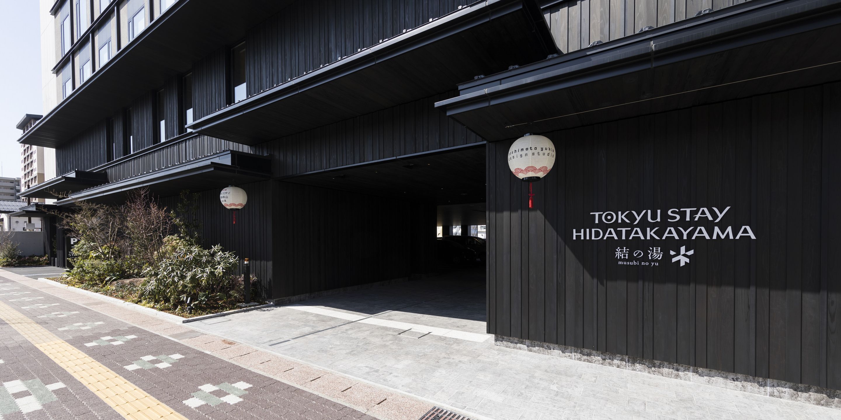 Een modern gebouw met een bord voor TOKYU STAY HIDATAKAYAMA.