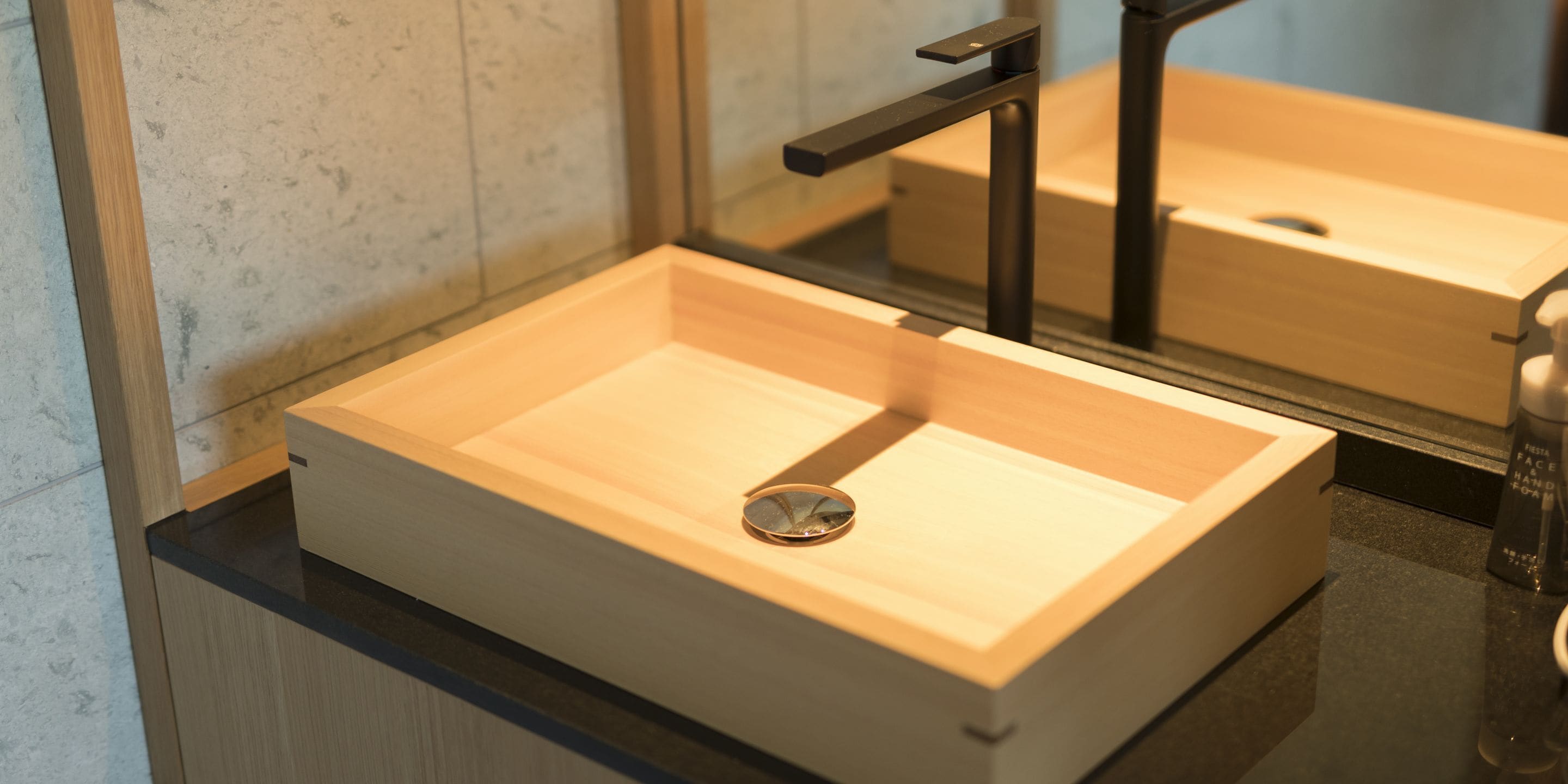 A bathroom with a wooden vanity, a sink, and a mirror.