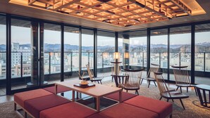 Une chambre d’hôtel moderne avec de grandes fenêtres, un plafond en bois et une vue sur la ville.