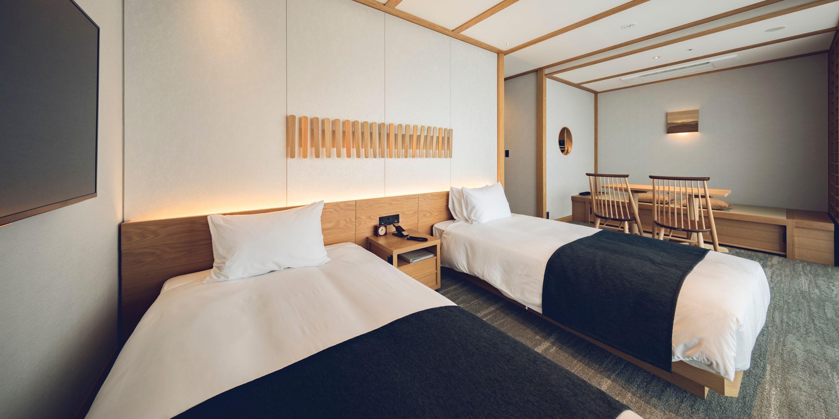Una habitación de hotel con dos camas, un escritorio y una silla.
