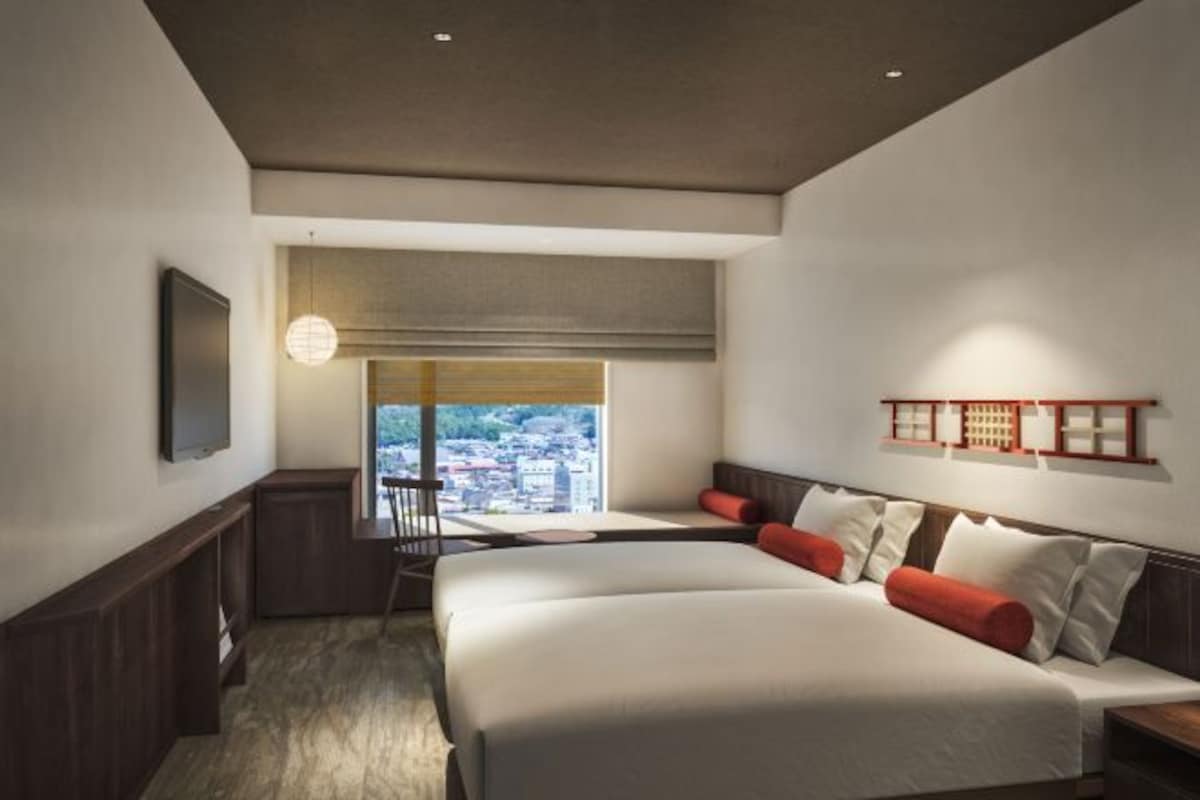 Une chambre d’hôtel moderne avec un grand lit, un bureau et une vue sur la ville.