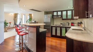 A modern kitchen with a central island, bar stools, a refrigerator, a microwave, and a sink. - Uber Luxurious NYC-Style Penthouse, Two Minutes Walk from Long Street (Cape Town)