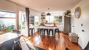 Une cuisine moderne dotée d’un îlot central, de tabourets de bar et d’un coin repas avec une table et des chaises.