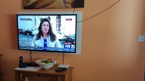 Un televisor instalado en una pared mostrando un canal de noticias.