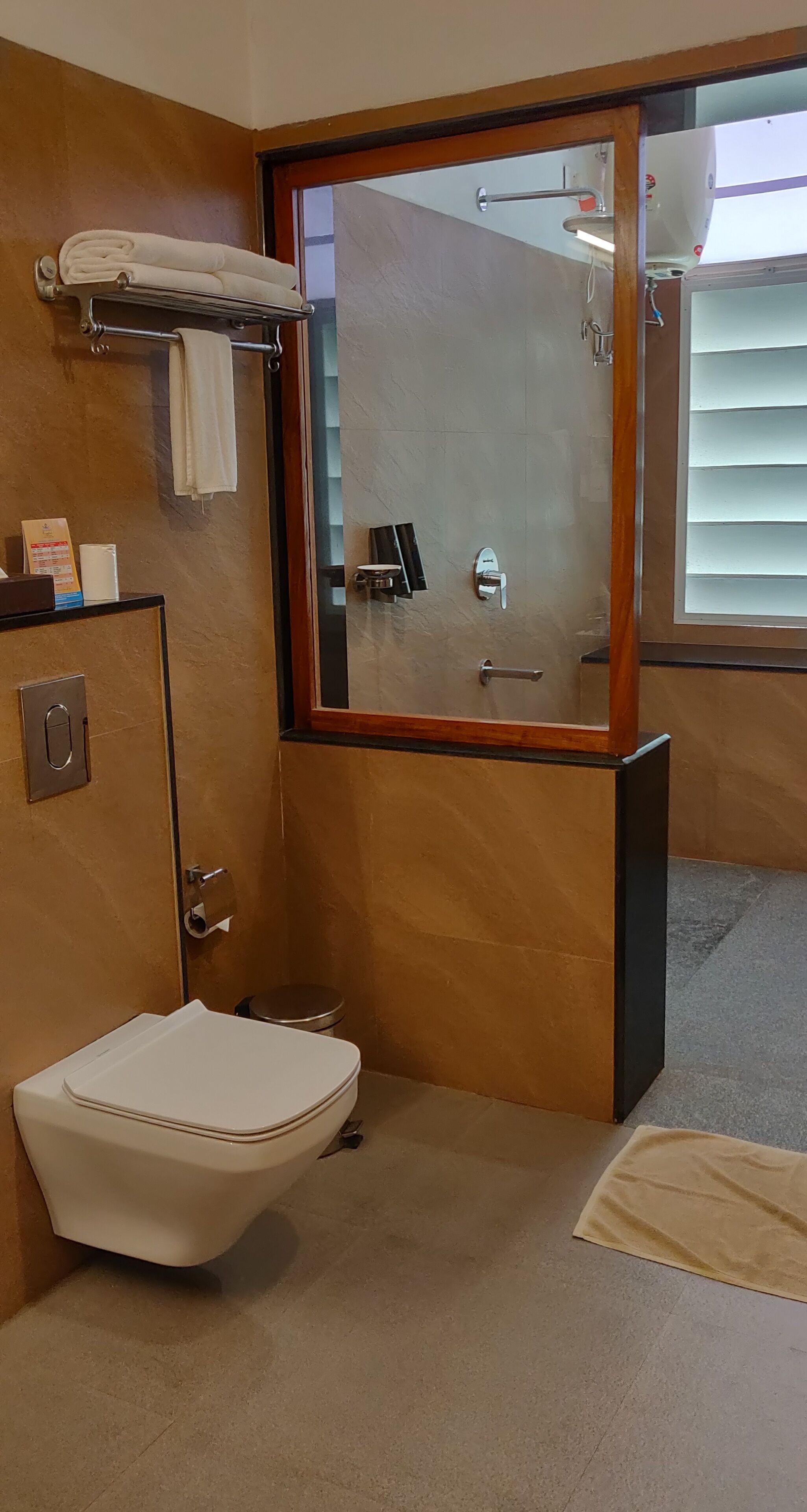 Un baño pequeño con inodoro, lavamanos y toallero.
