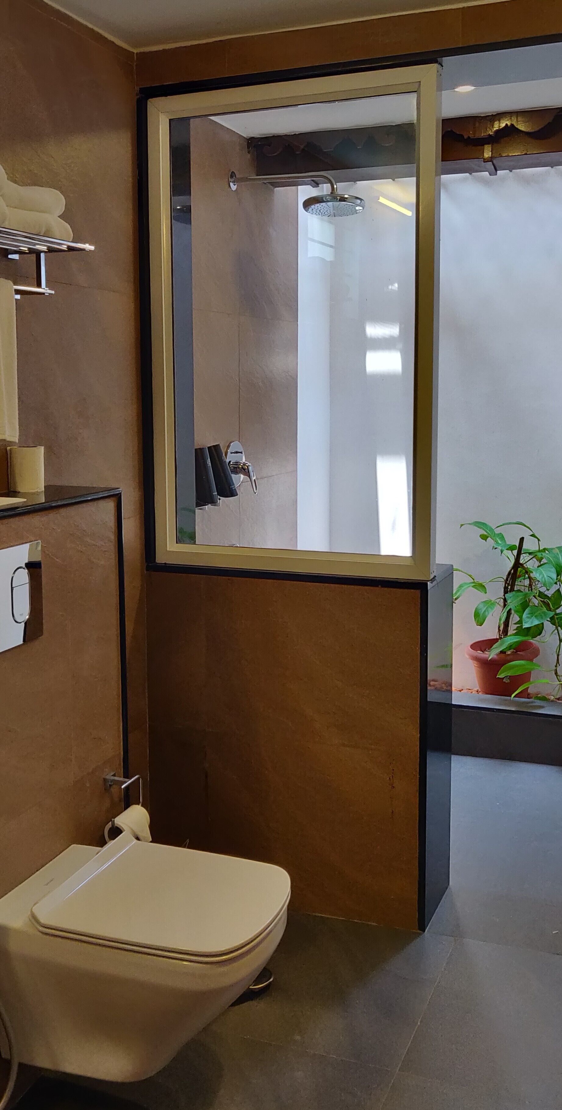 A modern bathroom with a toilet, a sink, a mirror, and a shower.