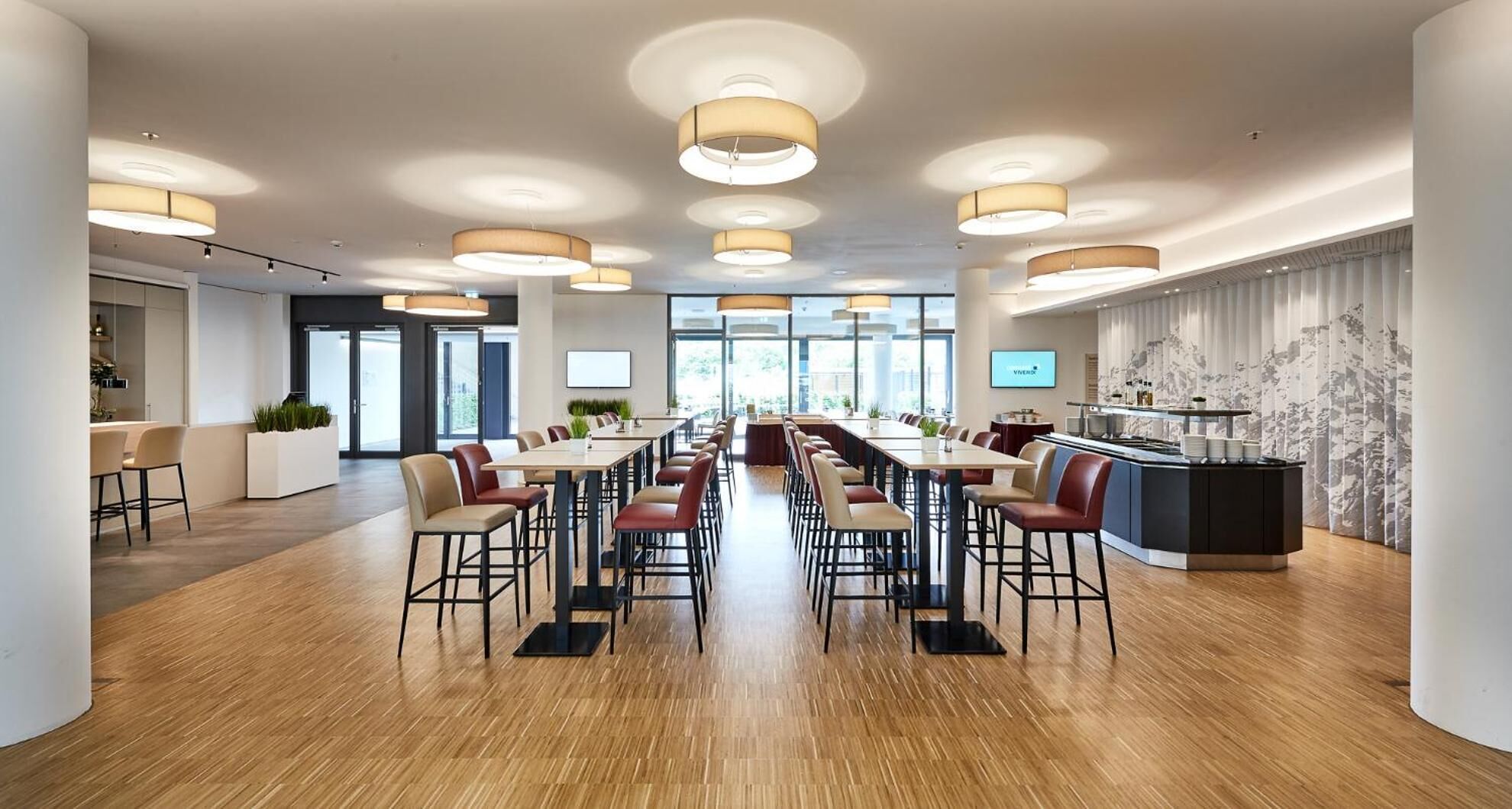 Une salle de conférence moderne, dotée d’une longue table, de nombreuses chaises et d’un îlot central avec un bar.