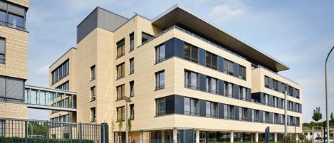 Un edificio moderno de varios pisos con techo plano y amplias ventanas.