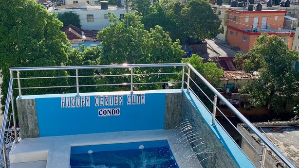 A swimming pool with a view of the cityscape in the background. - Higuey Center City, Candyland 2 bedroom  (Higüey)