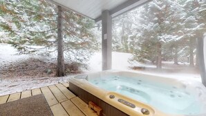 A hot tub in a covered outdoor area with a view of snow-covered trees. - Alpine townhouse w/ hot tub & A/C (Whistler)