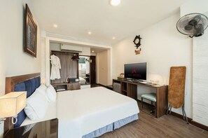 Une chambre d’hôtel équipée d’un lit, d’un bureau, d’une télévision et d’un miroir.