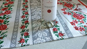A bottle of Chardonnay on a table with a floral tablecloth. - Nostalgy House Moldova (Râşcani)