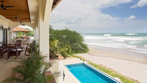 A beachfront property with a pool, outdoor seating, and a view of the ocean. - Fort Walker (Beachfront House) (Hacienda Iguana)
