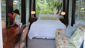 A bedroom with a bed, bedside tables, a desk, a chair, and a sofa. - Palm Cottages - Entire Compound - Tropical Oasis (Vieques)