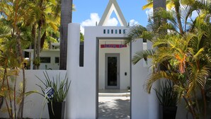 A gated entrance with a sign reading "Blavos Boyz" and a triangular architectural feature above the door. - Palm Cottages - Entire Compound - Tropical Oasis (Vieques)