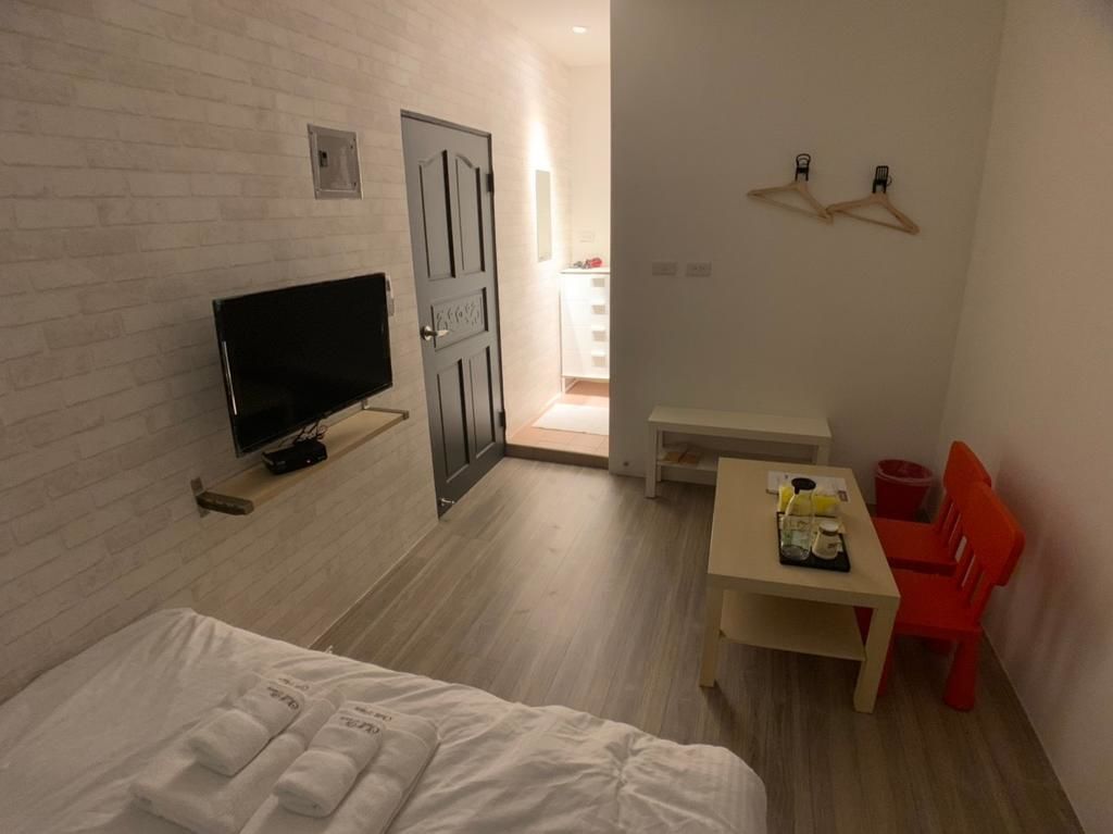 A hotel room with a bed, a TV, a desk, and a chair.