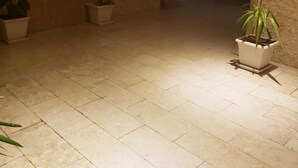 A hallway with tiled flooring, potted plants, and a fire extinguisher on the wall. - Arkin Daire 1 bedroom (Alanya)
