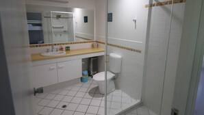 Une salle de bain avec une douche à parois de verre, un lavabo et des toilettes.
