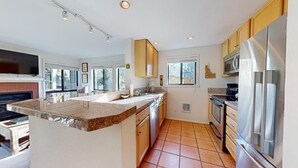 A modern kitchen with granite countertops, stainless steel appliances, and wooden cabinets.