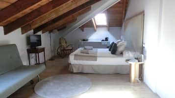 Quarto com cama, sofá, televisão, cadeira e escrivaninha.