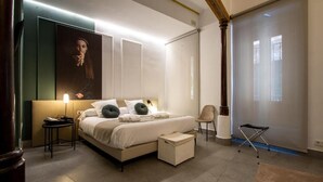 Een moderne slaapkamer met een groot bed, nachtkastjes, een stoel en een groot raam.