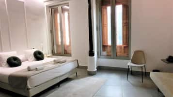 A bedroom with a bed, a chair, and a window with curtains.