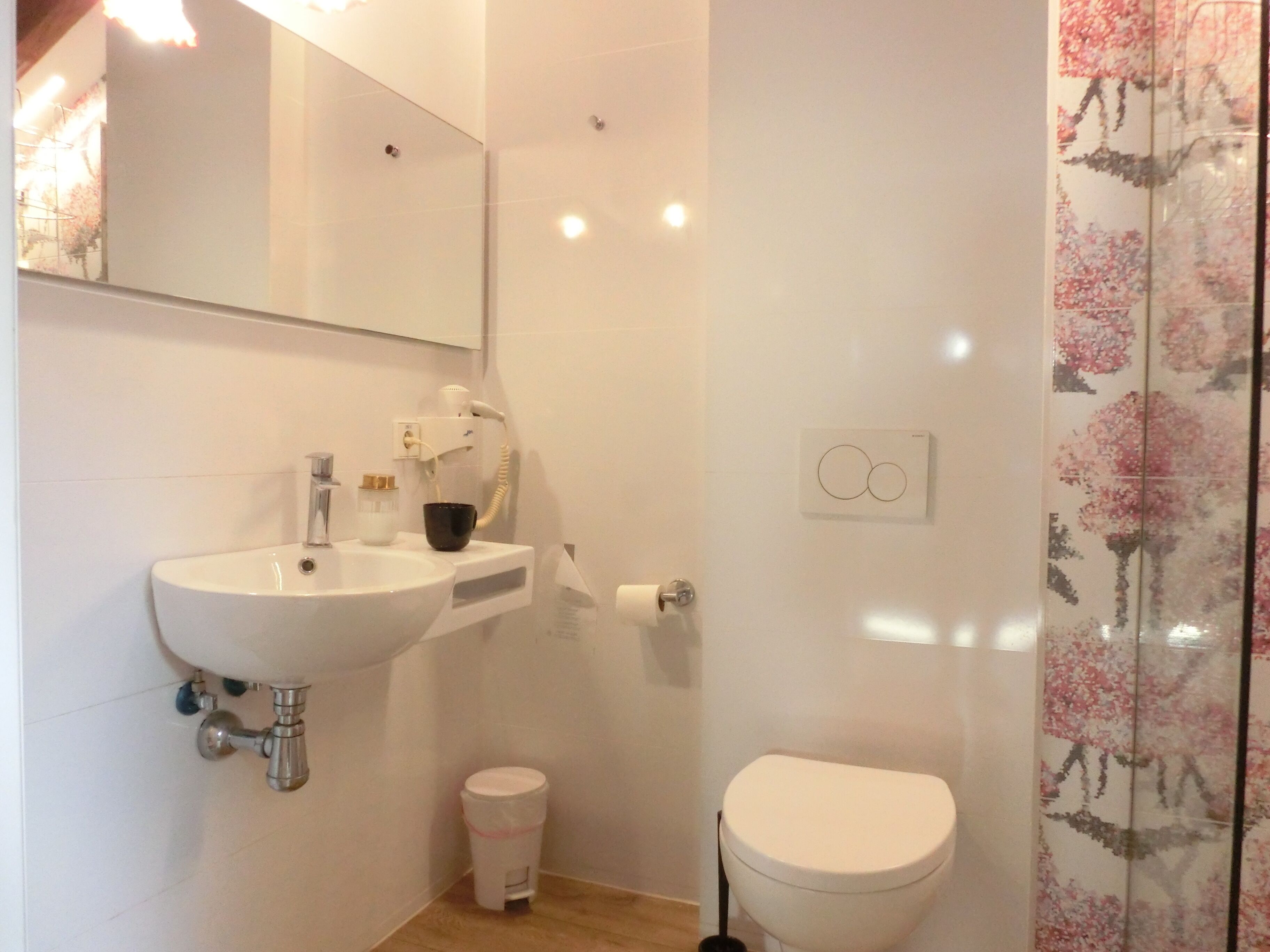 Un baño con un lavamanos blanco, un inodoro y un espejo.