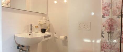 Un baño con un lavamanos blanco, un inodoro y un espejo.
