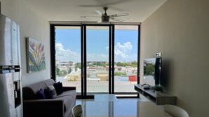 Una sala moderna con un sofá, una mesa de comedor y un televisor.