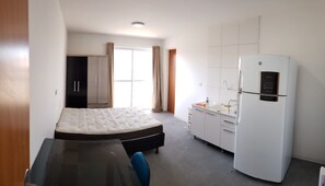 Cozy retreat with a single bed, compact table, and sink.