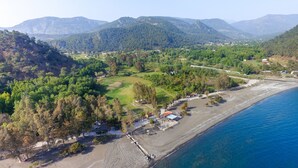 Vista aérea de una zona costera con playa, carretera y edificios dispersos.