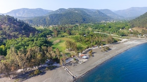 Enjoy a tranquil beachside retreat with stunning views of the surrounding hills and lush greenery.