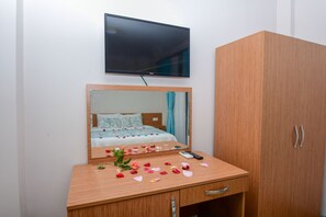 Relax in a stylishly designed room with a flat-screen TV, wooden vanity, and ample storage.