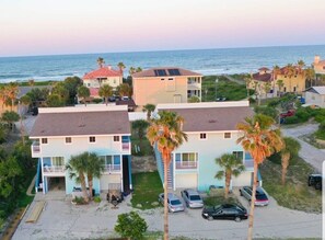 A coastal residential area with houses featuring balconies and solar panels, a sandy beach, and a clear view of the ocean. - Cozy Relaxation on Crescent Beach (St. Augustine)
