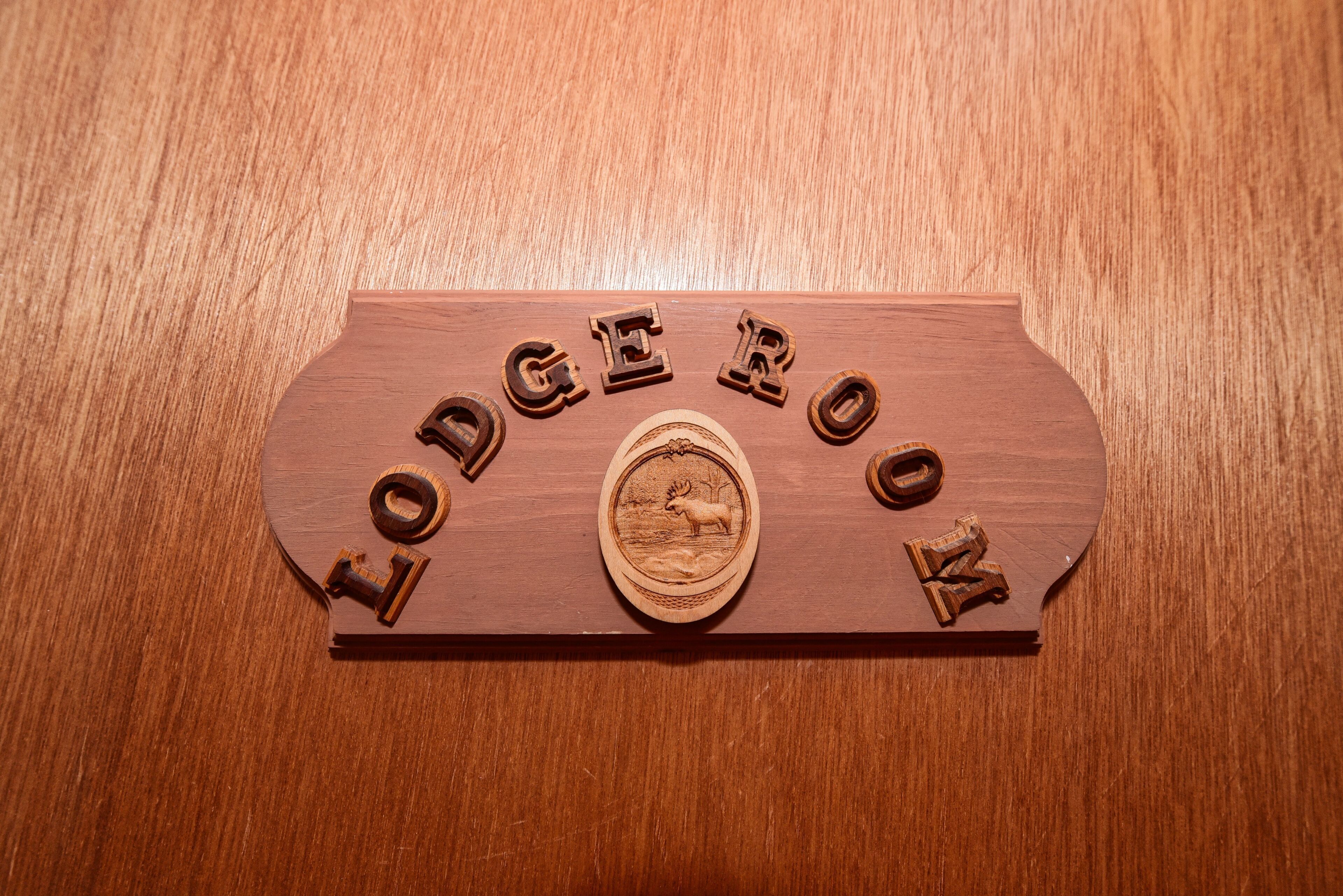 A wooden plaque with the words "Lodge Book" and a moose illustration.