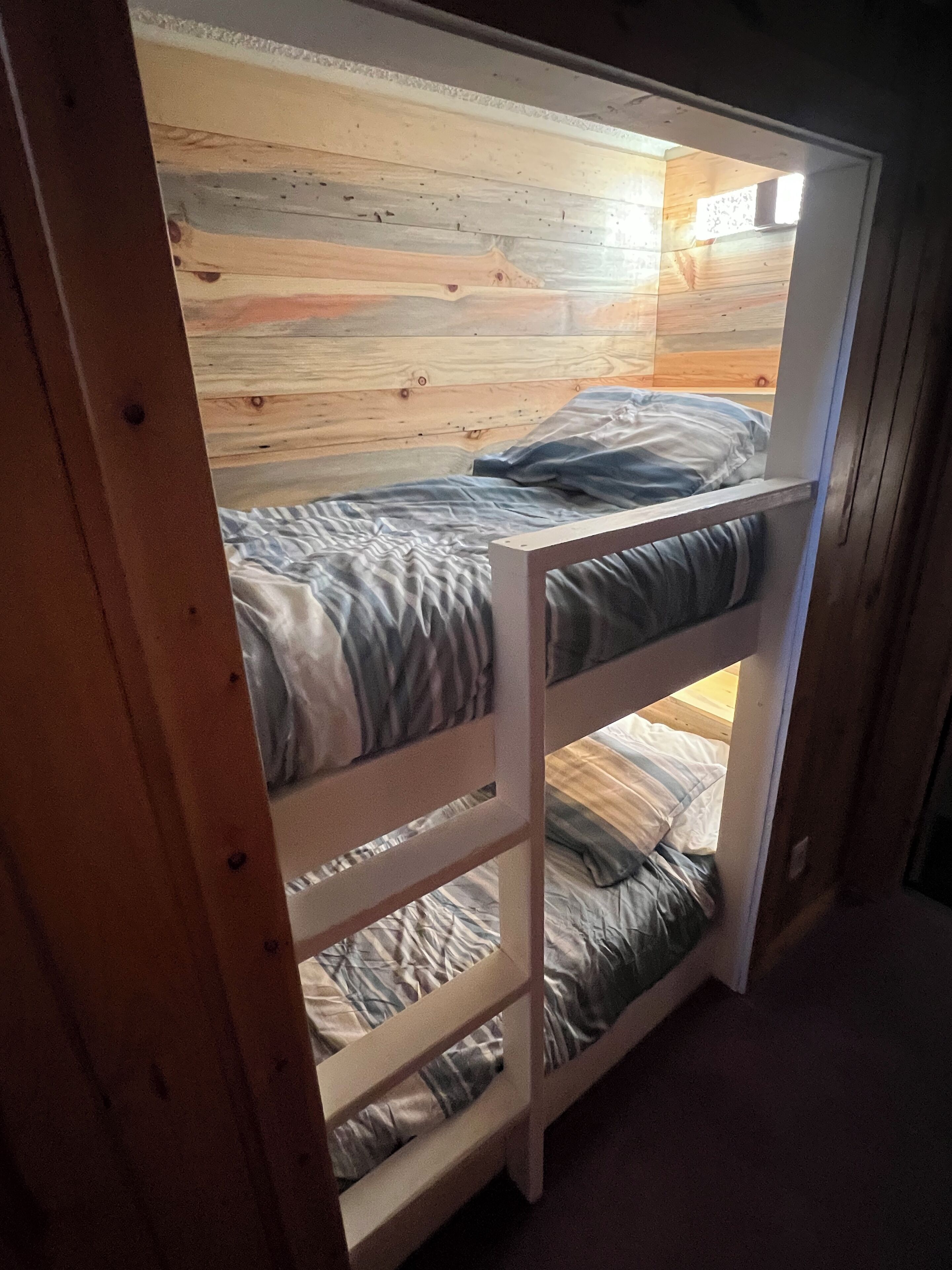 A bunk bed with a wooden headboard and a lower bunk.