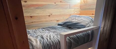 A bunk bed with a wooden headboard and a lower bunk.